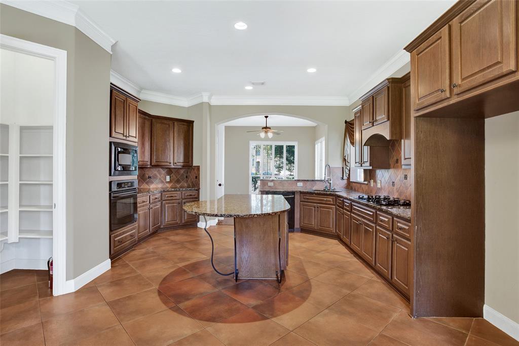 The well-appointed kitchen boasts granite countertops, a gas cooktop, a dishwasher, a microwave, and a range/oven