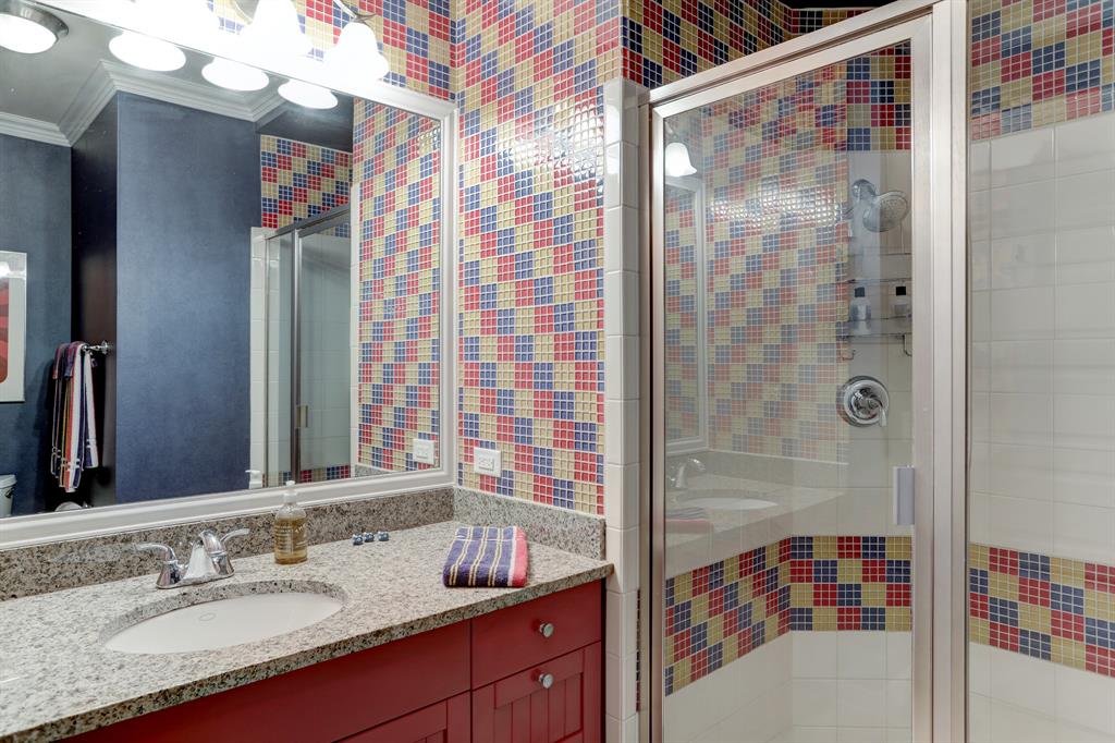 The Third Bath features a delightful shower with playful and eye-catching custom tile work, adding a touch of personality and charm.
