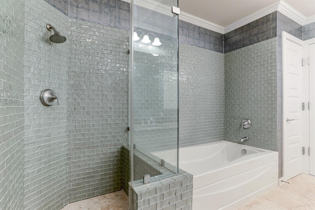 Indulge in a blissful retreat within the Primary Bath, where a separate shower and tub adorned with custom tile await you, creating a luxurious and inviting oasis to enjoy and unwind.