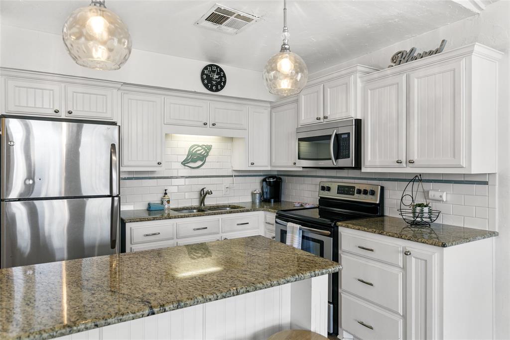 Updated kitchen with stainless appliances and granite countertops.