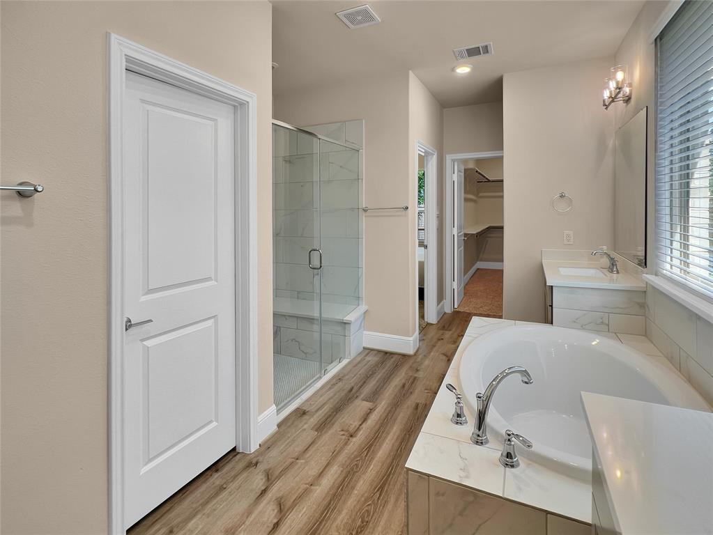 Primary bathroom with tub and shower, double sinks.