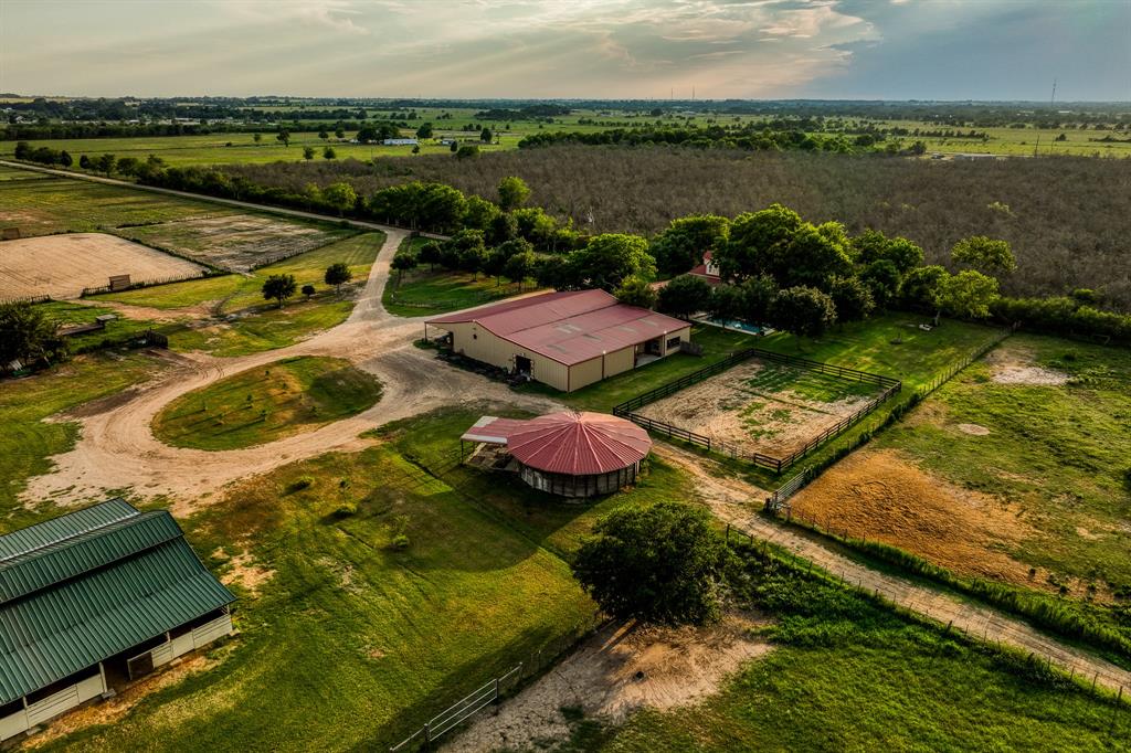 Evening aerial view of barns, round pin, circle drive, pastures and main home.