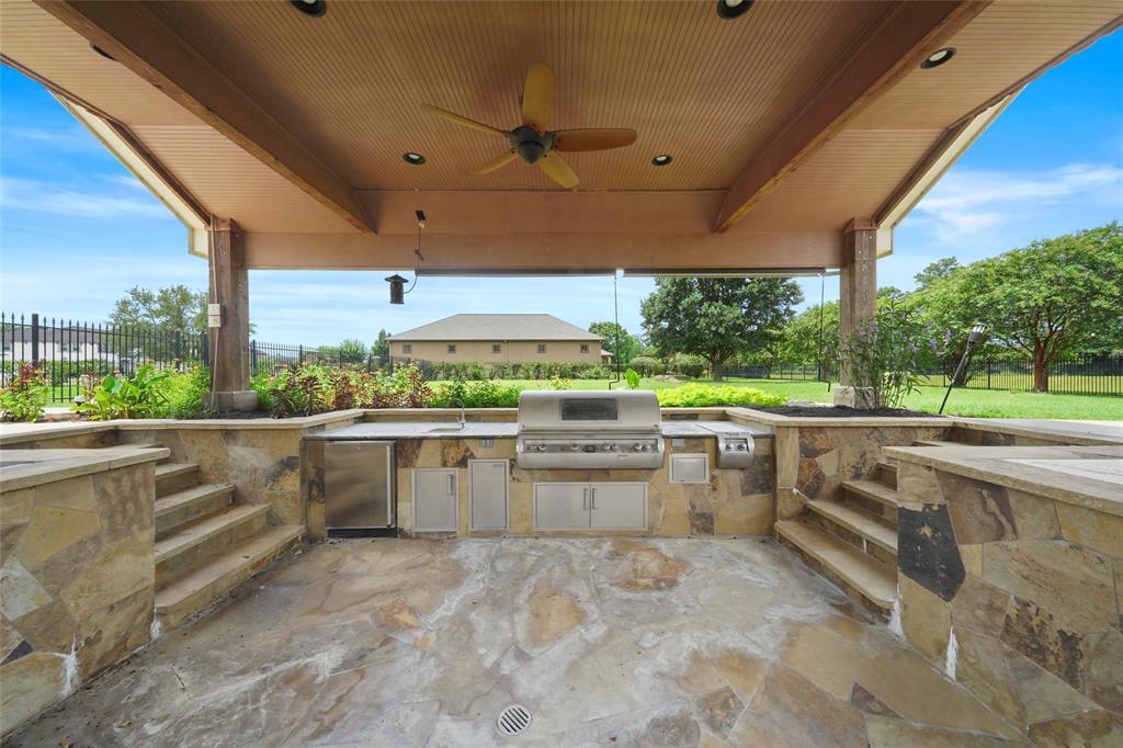 Outdoor kitchen in the scenic landscape and sunkin step down dining and pool covered lounge area with access to swim up pool bar