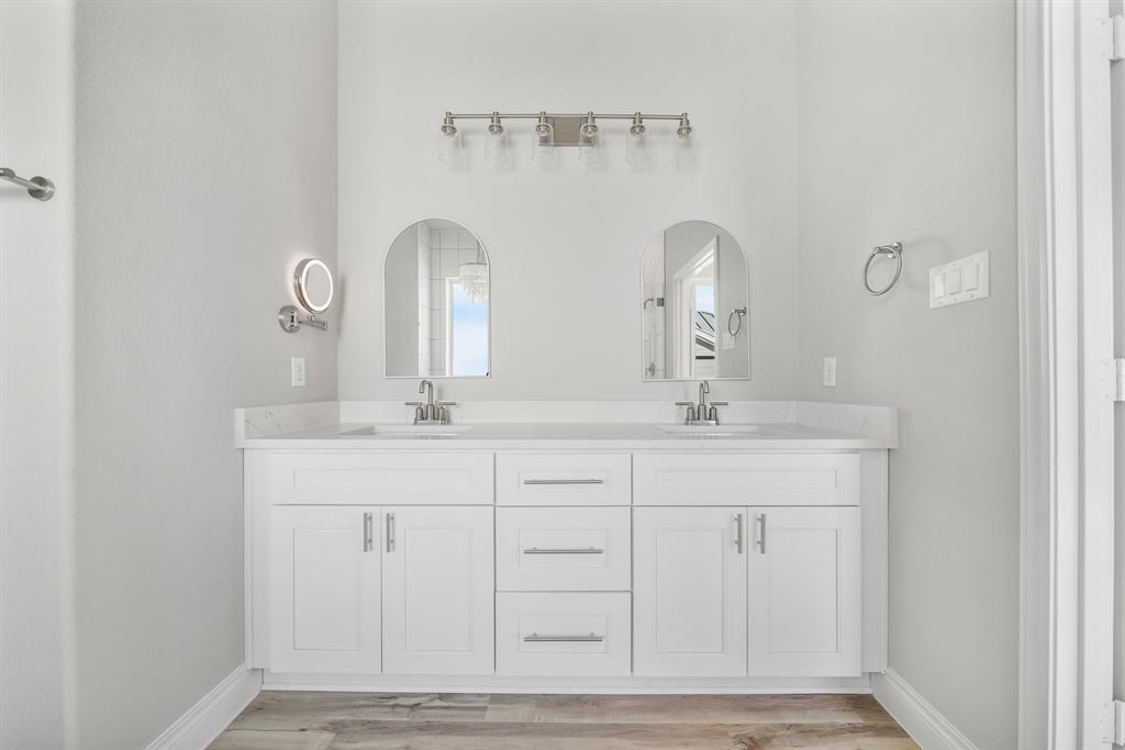 Primary bathroom- double sinks, brushed nickel fixtures, high ceilings, & quartz counters!