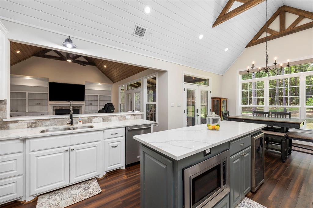 Step into this beautiful, modern kitchen. Cathedral ceilings and beautiful wood accents. The open kitchen is a chef\'s delight complete with plenty of quartz countertops, double ovens, gas cooktop with pot filler, large island and built in microwave and wine refrigerator.