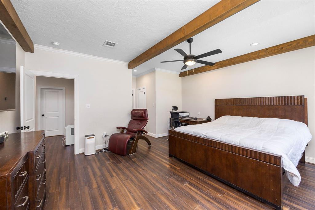 Step into your very own private oasis. The luxurious primary bedroom offers high ceilings and decorative wood beams that add a hint of sophistication and charm. Beautiful bamboo floors throughout