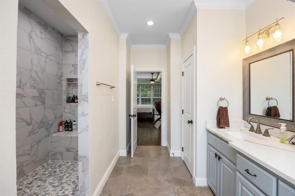 This primary bathroom is the perfect place to relax and unwind after a long day. Custom built cabinets, double sinks, and a large free standing soaking tub are sure to provide you with the ultimate spa-like experience. Plus, the large window next to the tub lets in plenty of natural light for an extra tranquil atmosphere. When it\'s time for a refreshing shower, you\'ll love having access to a spacious walk-in shower. His and her closets offer plenty of storage space