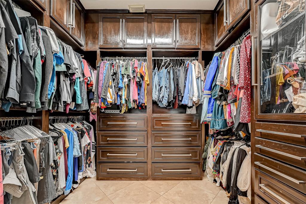 Primary closet with custom built in shelves and drawers