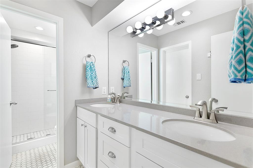 The updated bathroom offers a double sink vanity.