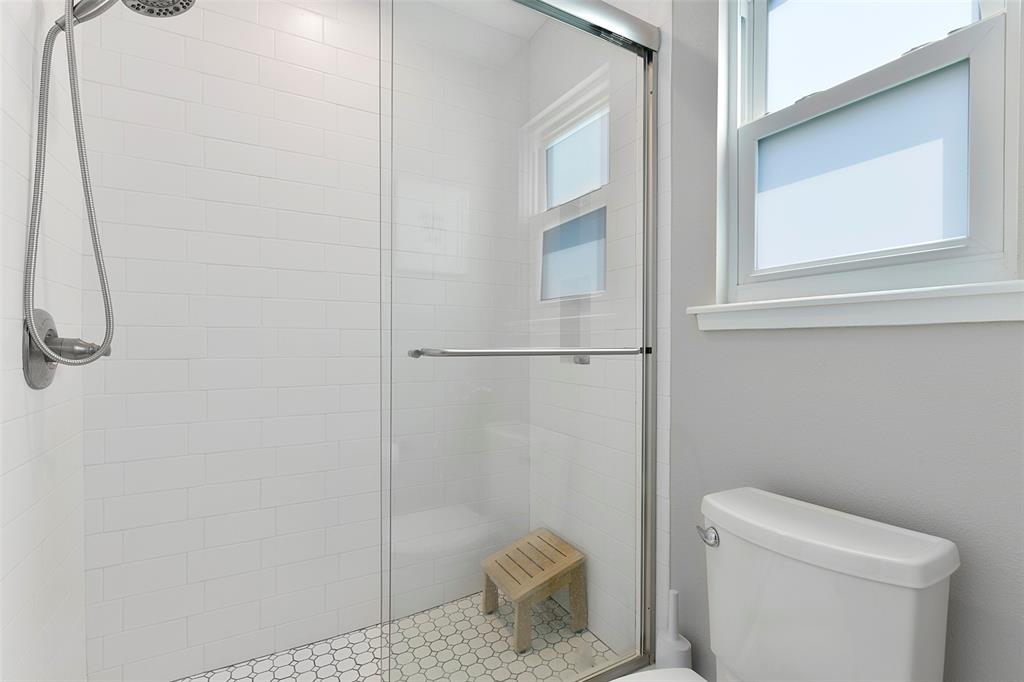 The commode and shower are housed in a separate room from the double sink vanity.