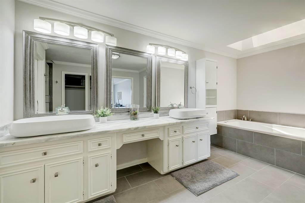 Talk about a luxurious bathroom with dual vanities, granite counters and a soaking tub with skylight above.