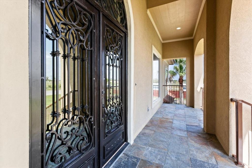 Front Porch That Has Slate Tile*Massive Front Doors With Metal Scrolled Insert.