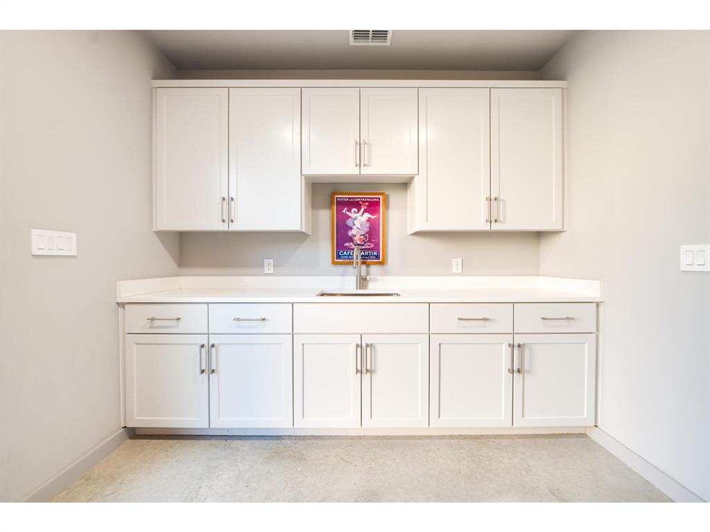 Large laundry room with sink and abundant storage space