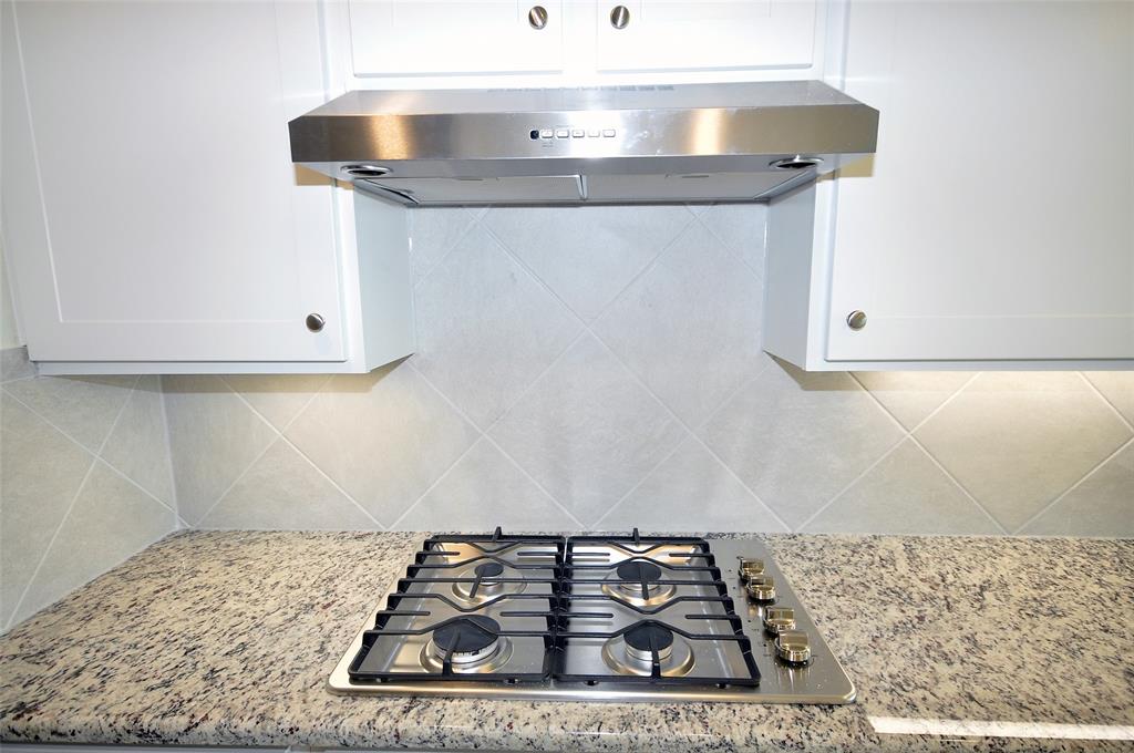 Stainless appliances include a gas cooktop which is vented to the exterior.