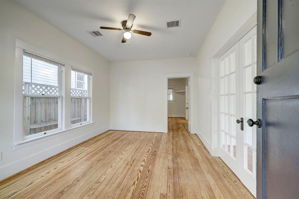 Completely restored original long leaf pine floors throughout house.  Note the antique French doors separating the living and dining spaces.