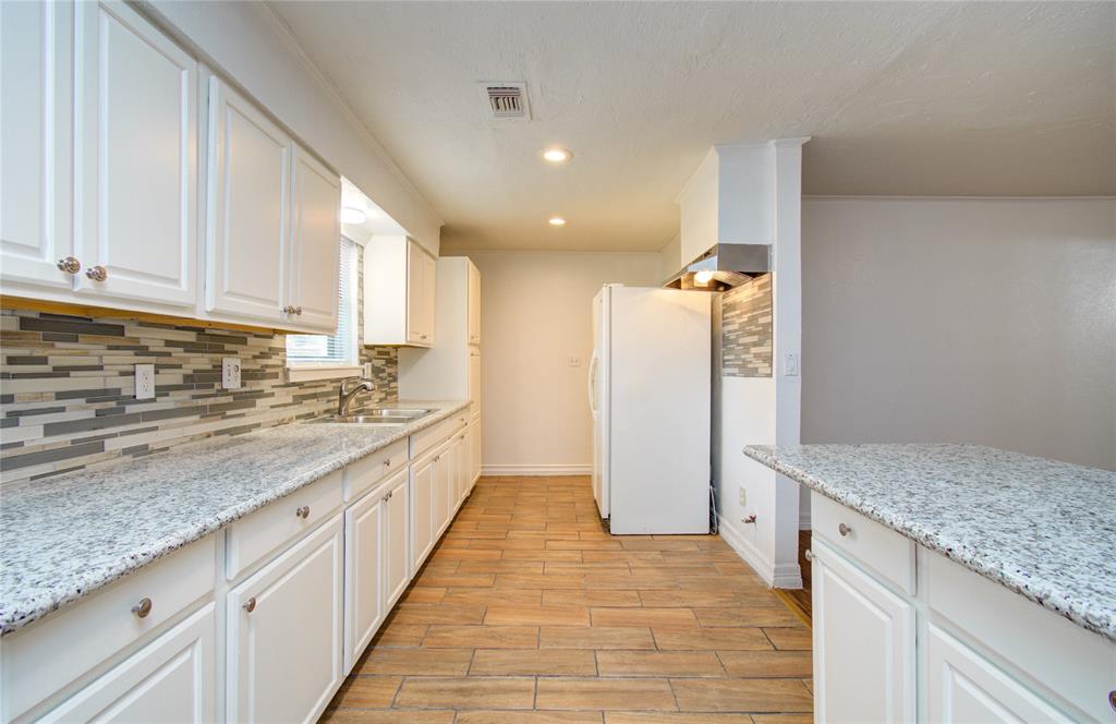 Recently renovated kitchen with island and lots of cabinets and granite countertops, open to the family room