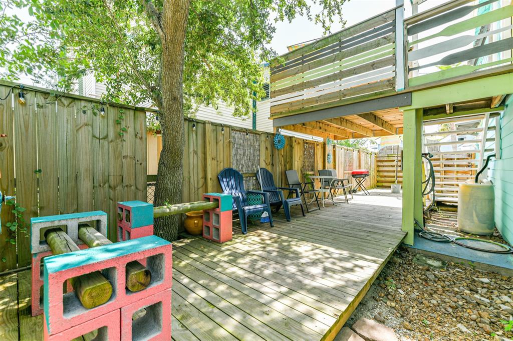 Experience ultimate outdoor relaxation with an expansive wooden deck nestled under the shade of a majestic tree.