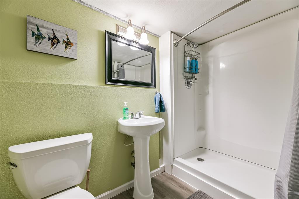 Downstairs bathroom with pedestal sink and walk-in shower.