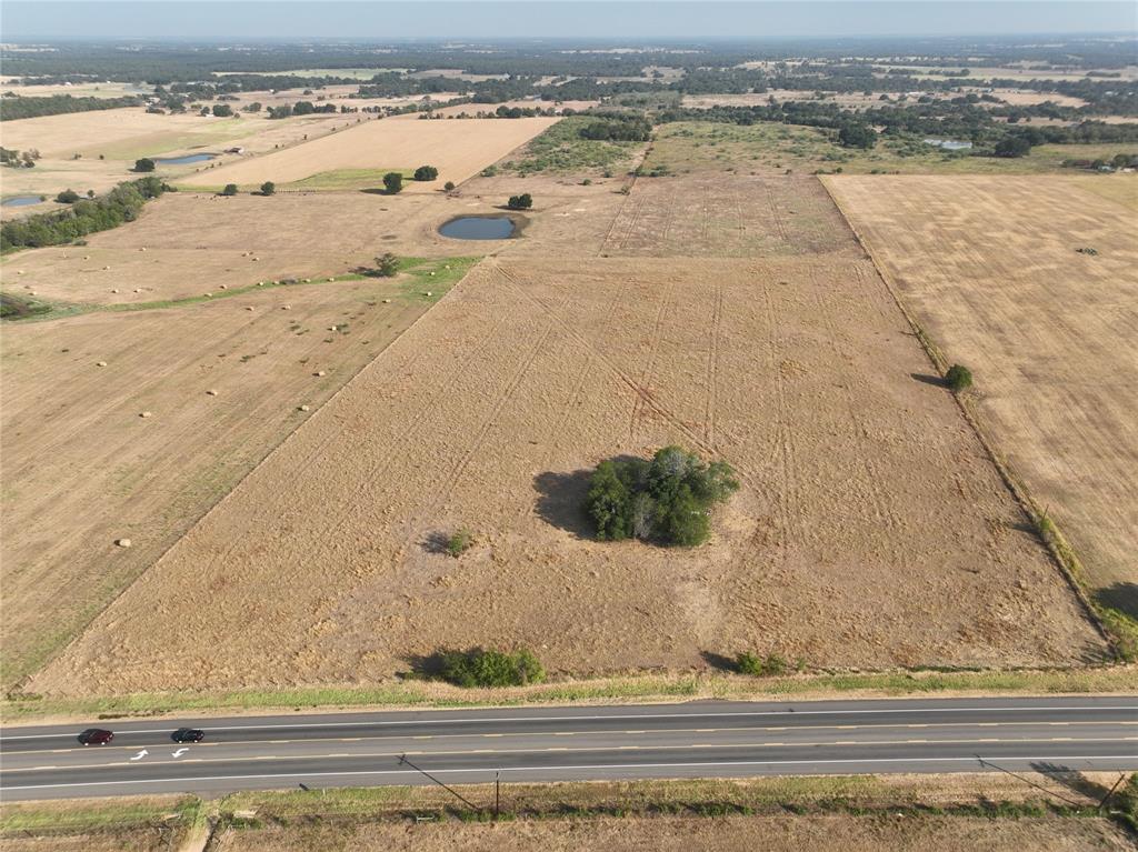 This 18 acres is ideal for commercial, agriculture, or a homestead. Centrally located in Dime Box with Highway 21 road frontage between Austin and Bryan/College Station. Currently being used for grazing. Ag exempt. Native grasses, mostly open pasture, land, sloping terrain, cluster of trees around old home that is not livable. No minerals. All sides fenced. Survey needed. Seller imposed restrictions: site built homes approved, commercial & storage buildings okay with approval, no mobile homes. Sold as is.