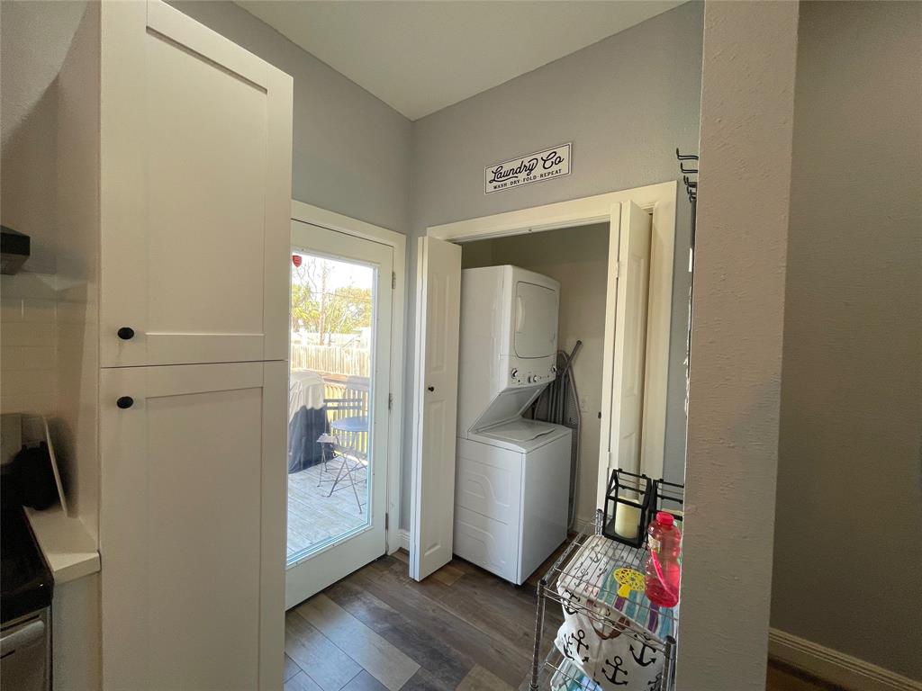 Laundry room off of kitchen includes a washer/dryer combo, ironing board and iron