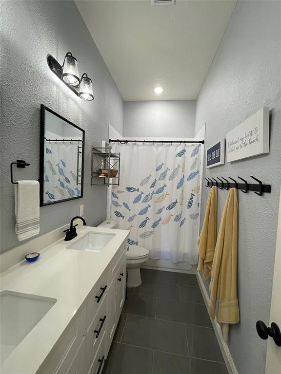 Updated bathroom includes vanity with double sinks, mirrors and updated fixtures. Tub/shower combo includes updated fixtures and white subway tile.