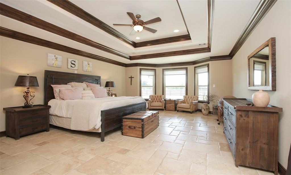 The lovely  huge primary retreat has a sitting area with large windows looking out to the backyard. Impressive tray ceiling and tile floors.