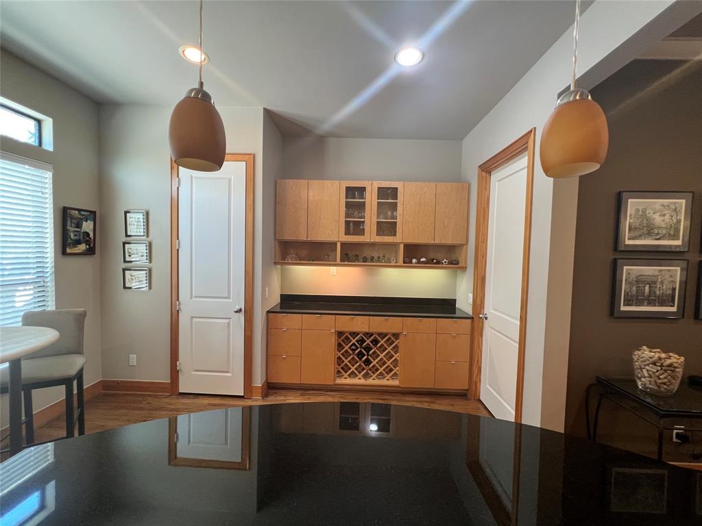 Custom built-in cabinetry with Granite counters, wine rack and display cabinetry for your beverage glasses.The pantry is to the left and the guest bathroom is to the right.