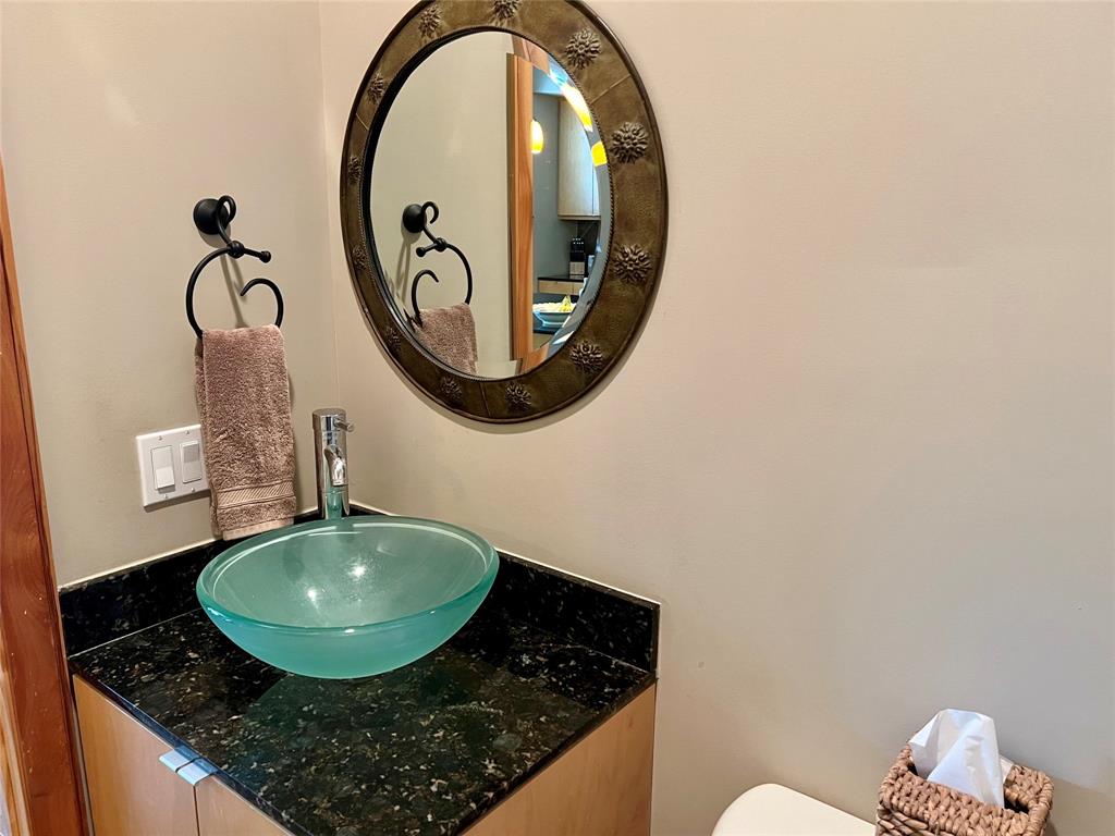 Guest bathroom with custom bowl sink, Granite counter with pedestal cabinetry with storage.
