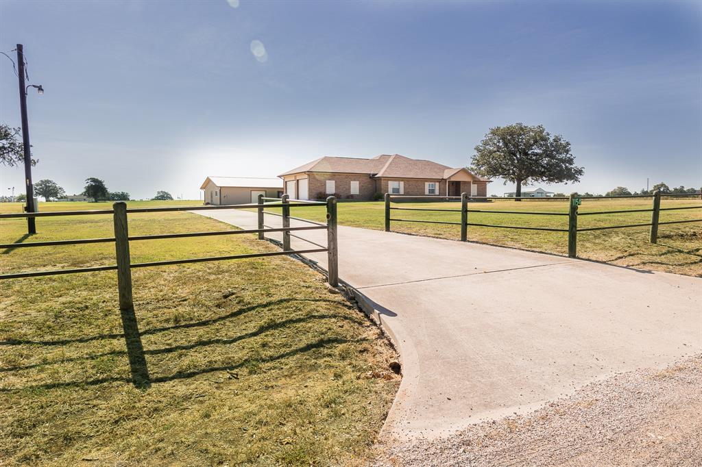 In an optimal location with easy access to Hwy 290, under a one hour drive to Austin and less than 5 miles to downtown Giddings is this beautiful ranch home on 10.5 acres with a large, stocked pond. The 2008 custom built home offers 2,878 sq ft with 3 bedrooms, 2.5 bathrooms, an office room and an oversized utility room. Buyers will appreciate the timeless features of tile throughout the home except for the bedrooms, recessed lighting, automatic lights in closets, vaulted ceilings in select rooms and custom, hardwood cabinetry. The kitchen boasts two sinks, quartz counters and under cabinet lighting. Smart investments to this home are spray foam insulation, a tankless hot water heater, handicap accessibility and a stairway to the attic storage above the garage plus additional attic storage above the house that is insulated. The property features scattered oak trees, pipe fencing along the front, livestock perimeter fencing and a 1,200 sq ft shop complete with a toilet and shower.