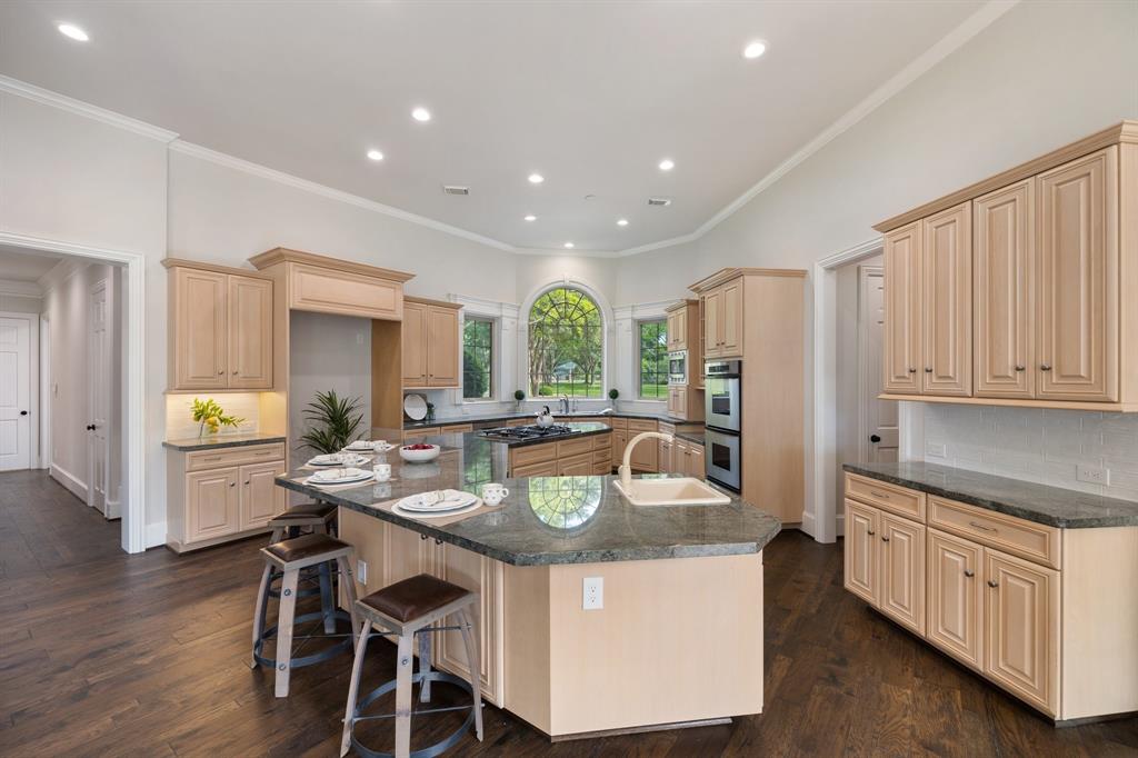 This kitchen is a dream come true!  Massive amounts of counterspace and cabinetry provide all the workspace and storage you can imagine.  Appliances are stainles steel and the layout is efficient and seemless.  That beatuiful window provides scenes from the oak tree-lined acreage up front.