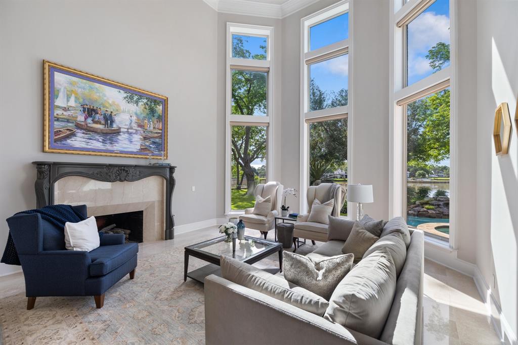 Stunning livin room with 2 story windows provide remarkablie fiews of the pool, water and yard.  Your guests will gather here and keep the conversation going all night long.
