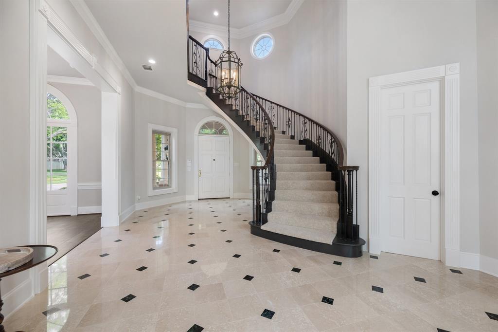 The dramatic foyer is anchored by a grand floating staircase.