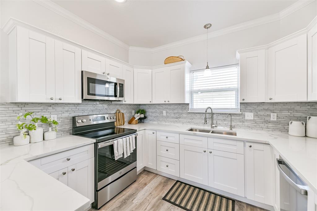White countertops and stainless appliances really make this kitchen pop!