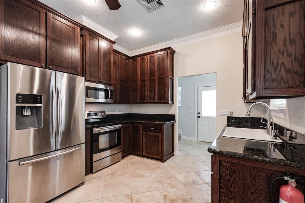 Well-planned space for this kitchen with includes stainless appliances, refrigerator included, custom cabinets, granite countertops and over-sized farmhouse like sink with in-sink divider.
