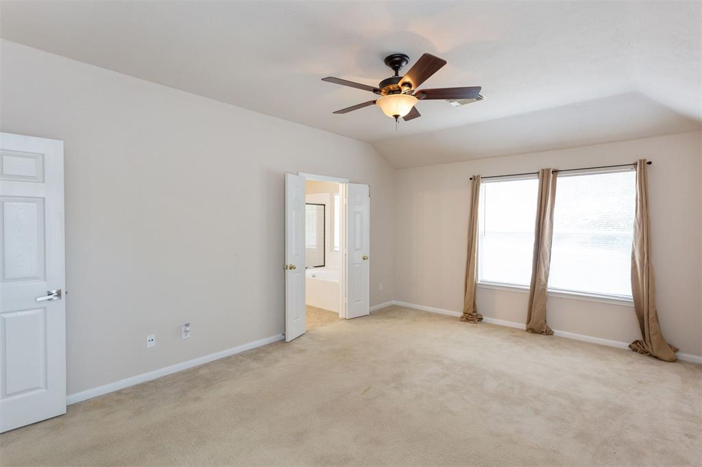 Huge upstairs primary suite! Light and bright with higher ceilings along with ceiling fan with light. Door in the distance leads to the primary bathroom.