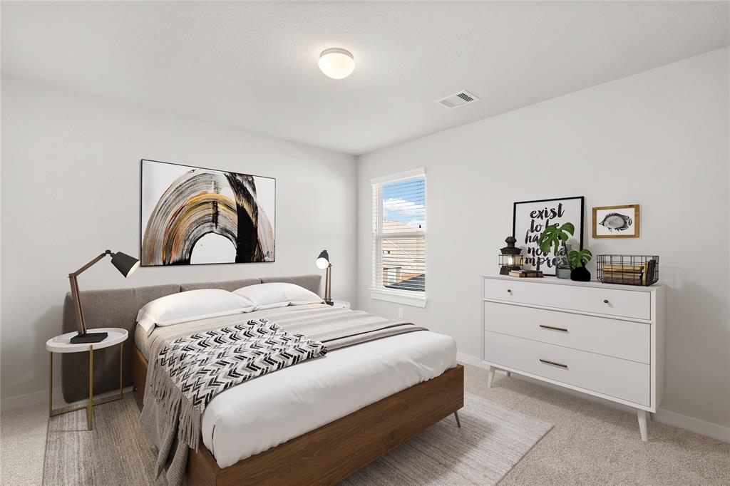 Secondary bedroom features plush carpet, custom paint and a large window with privacy blinds.
