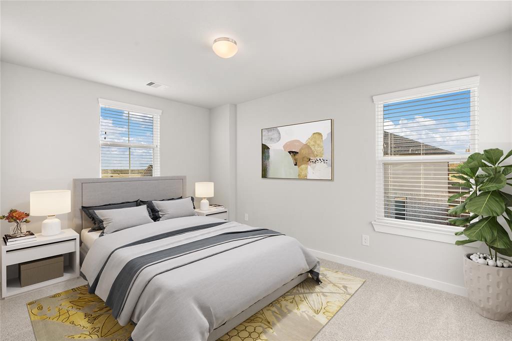 Secondary bedroom features plush carpet, custom paint and large windows with privacy blinds.