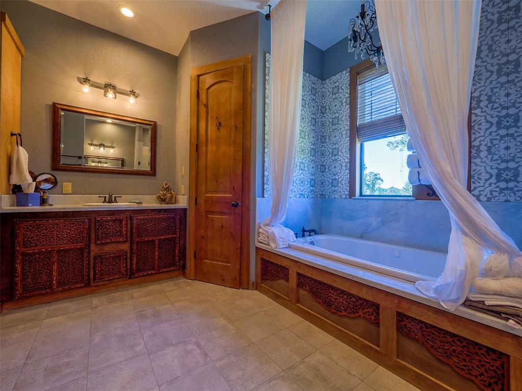 Upstairs primary bathroom has twin sinks, marble countertops, jetted tub and separate shower.