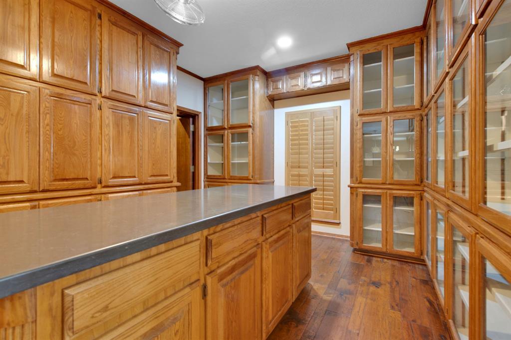 Second Island in kitchen with Quartz countertops leading to the butler\'s pantry. Store and showcase your glassware in these beautiful cabinets with glass inlaid.