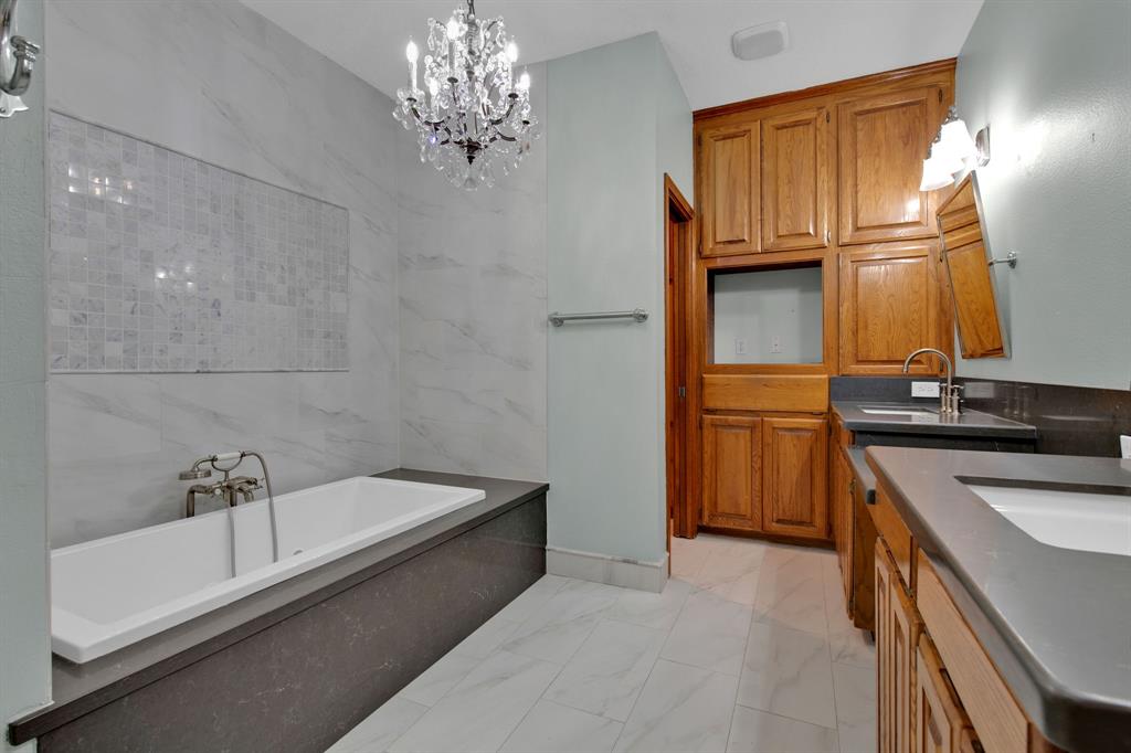 Designer finishes in this stunning bathroom. To name a few: Amazing Jacuzzi tub with shower head attachment, double sinks quartz countertops + luxury heated floors and towel rack to appease all!
