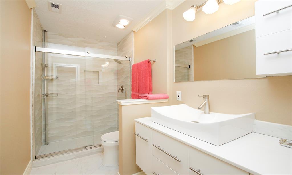 The primary bathroom has a large separate shower with sliding glass doors.