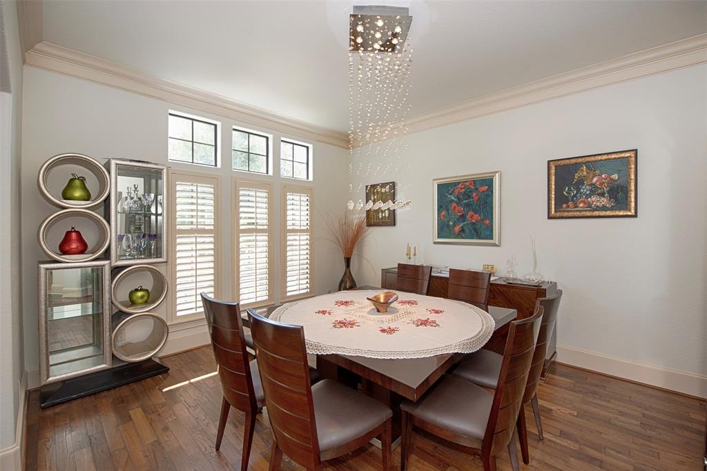Plantation shutters and crown molding are featured in this spacious dining room.