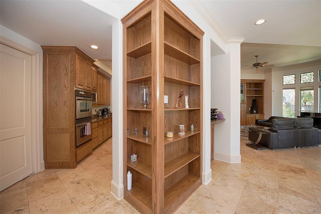 A built-in bookcase spotlights entry from the foyer to the chef\'s kitchen to the left and family room to the right.