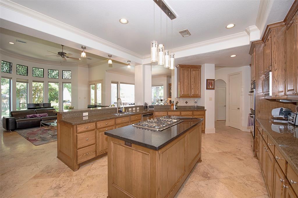 Lovely Travertine floors flow through the kitchen and family room, which is filled with natural light from the wall of windows.