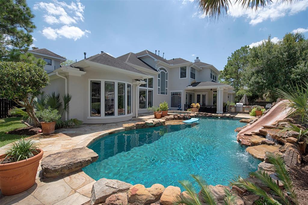The rear grounds have everything you could dream of - sparkling saltwater pool with waterfall, spa, outdoor kitchen  -  a vacation resort without leaving home..