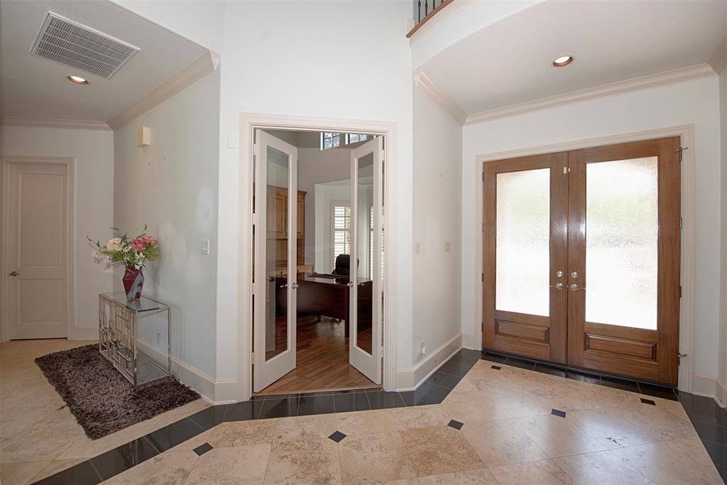 As you enter the home you are greeted with a high-ceiling foyer and gorgeous Travertine and hardwood flooring.  A home office/study is located off the foyer.