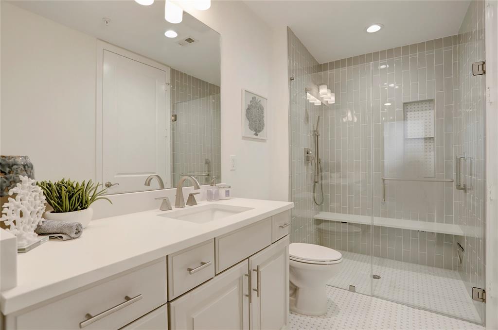 A spa-like ensuite bath boasts upgraded cabinetry and hardware, large vanity area and a walk-in shower fit for all with luxurious tile surround and bench seat.
