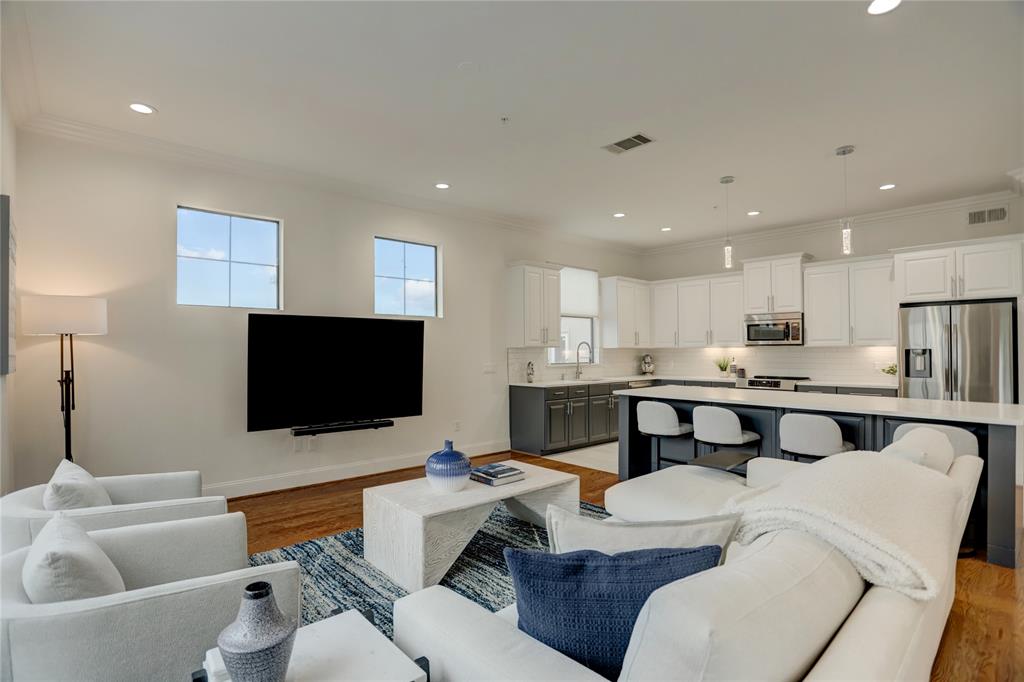 The large living/family room features recessed lighting, windows w/natural light, access to the private balcony, and open to kitchen/dining areas.