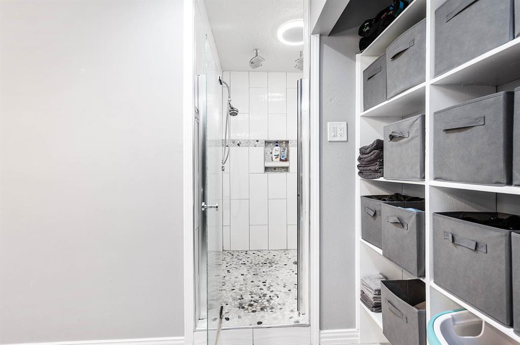 PRIMARY BATHROOM HAS WALK-IN SHOWER AND BUILT IN SHELVES WITH PLENTY OF STORAGE.