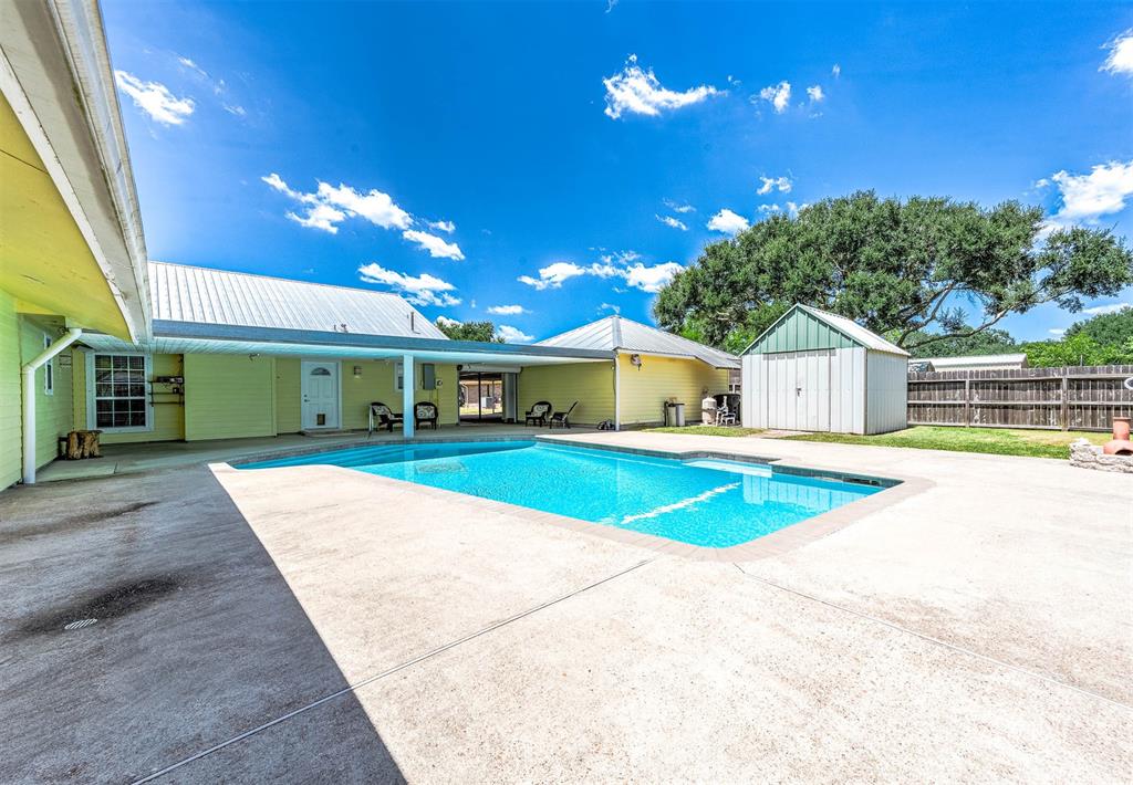 LARGE COVERED PATIO HAS THE PERFECT VIEW OF THE SWIMMING POOL AND POOL HOUSE.